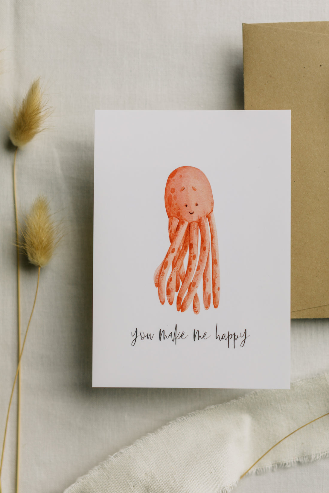 Postkarte roter Oktopus mit dem Aufdruck &quot;you make me happy&quot;