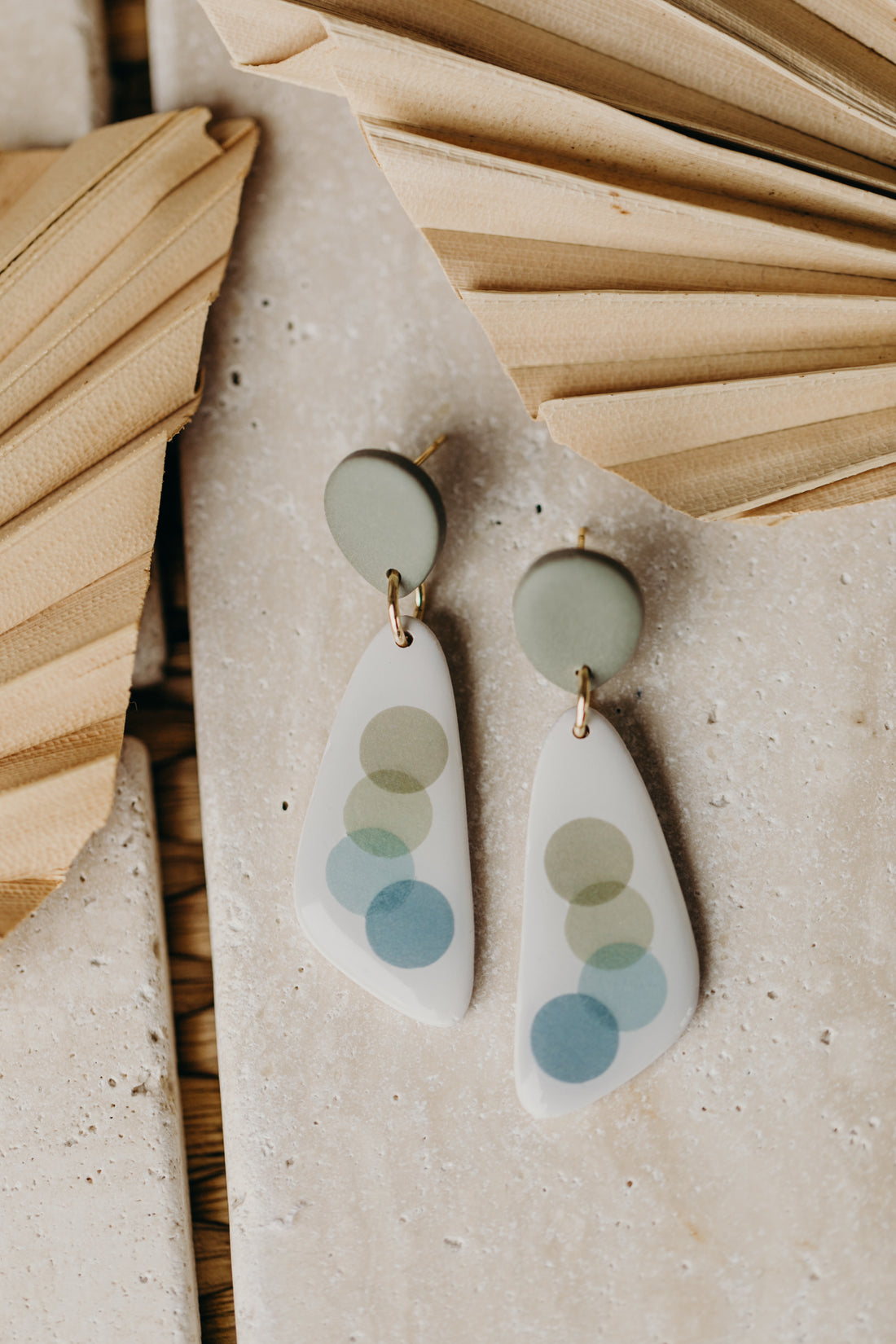 elongated green polymer clay earrings with blue and green dots