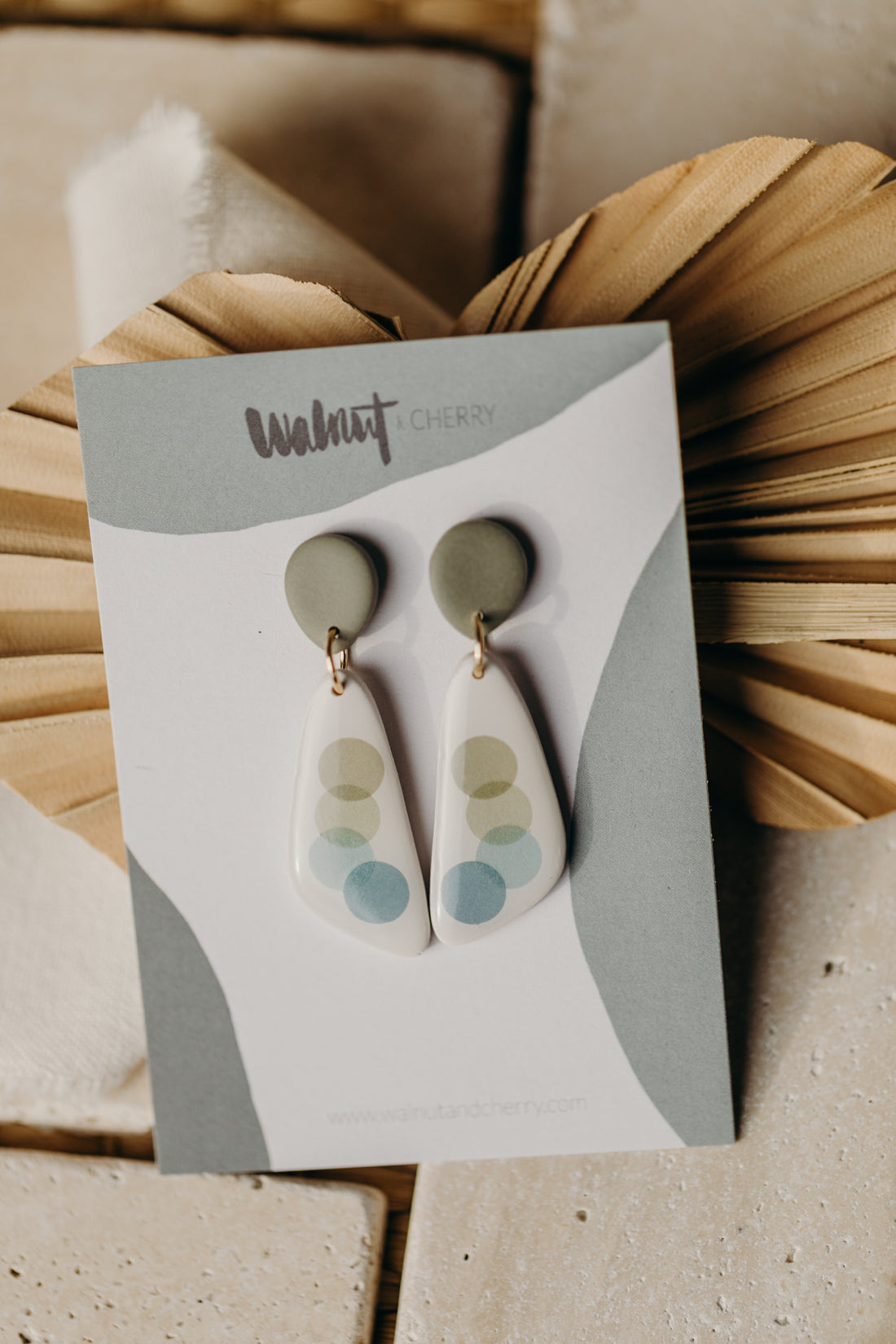 elongated green polymer clay earrings with blue and green dots