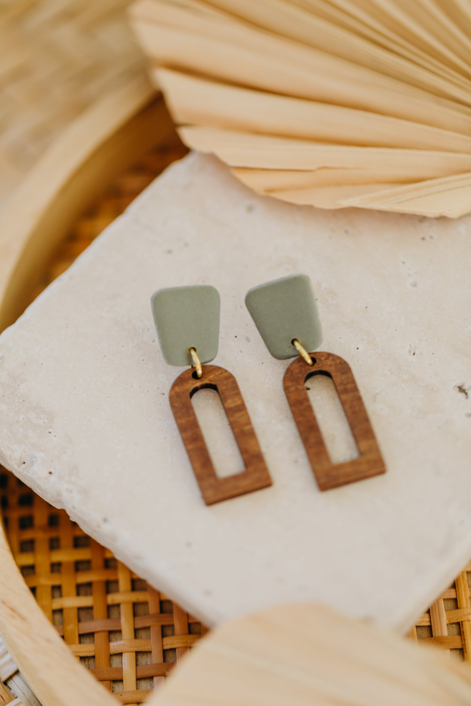 triangular polymer clay earrings in eucalyptus green with rectangular wooden pendant