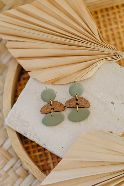 triangular polymer clay earrings in eucalyptus green with rectangular wooden pendant