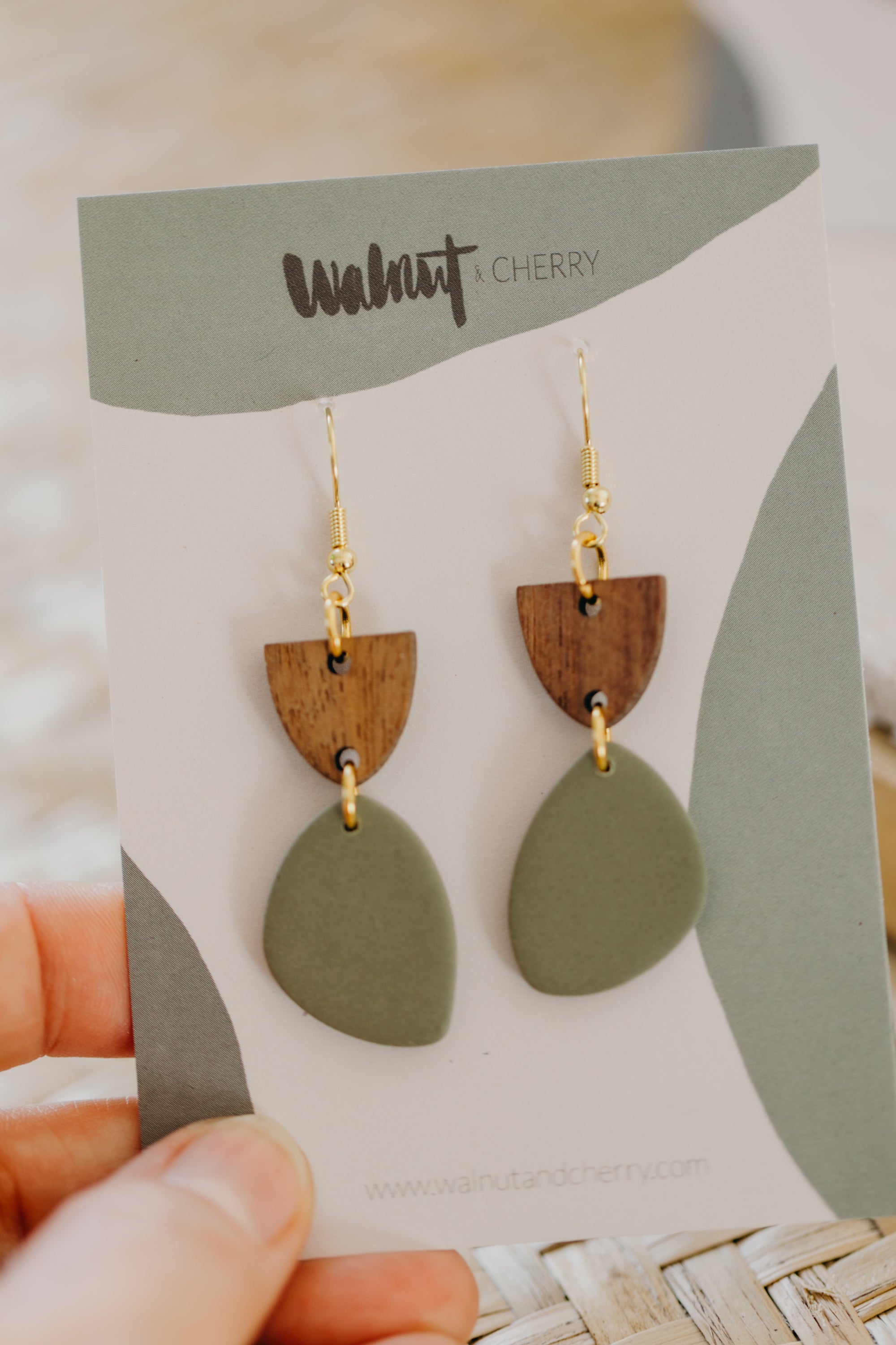 triangular polymer clay earrings in eucalyptus green with rectangular wooden pendant