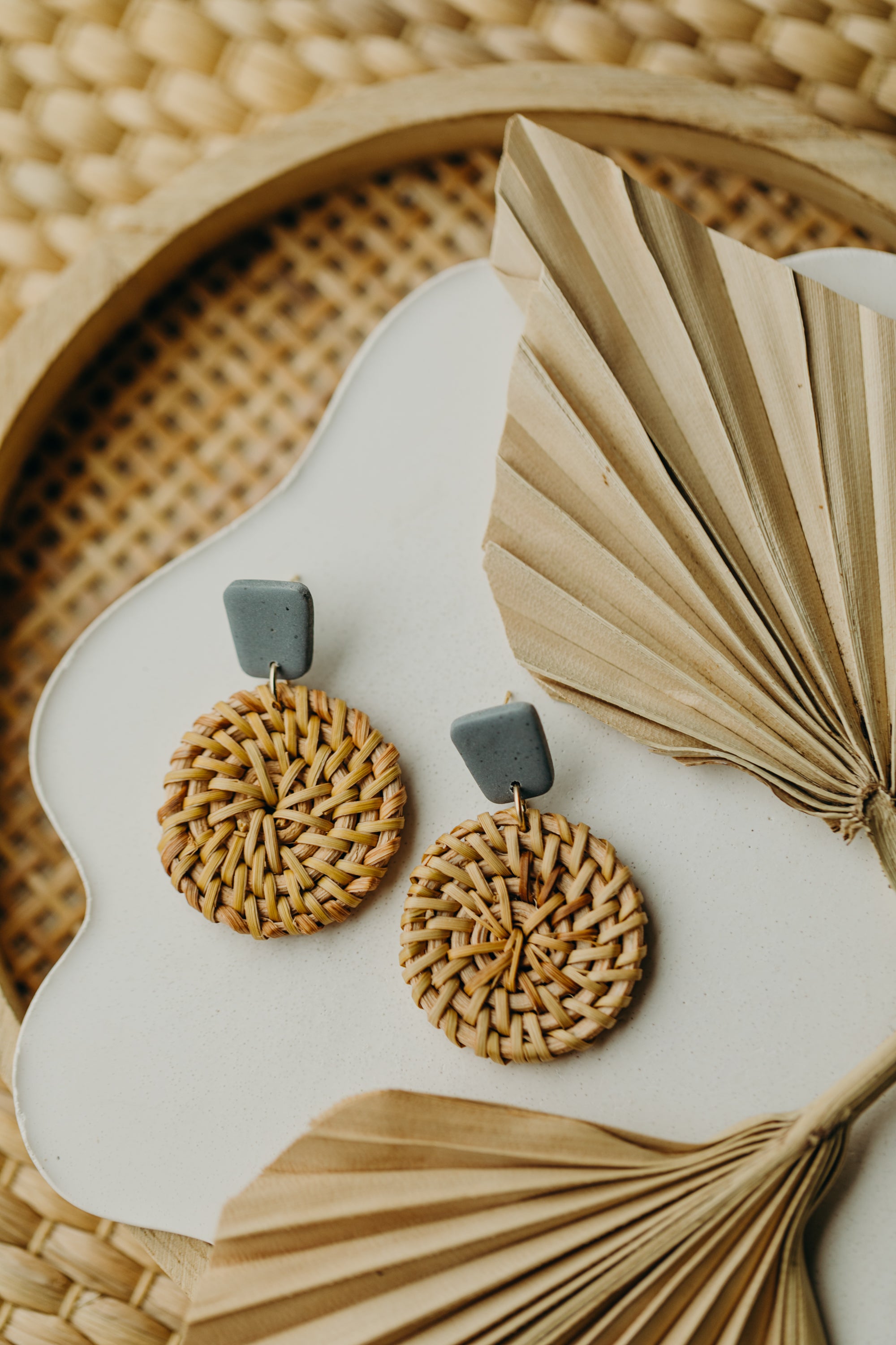 square polymer clay earrings in the color light denim blue with round rattan pendant