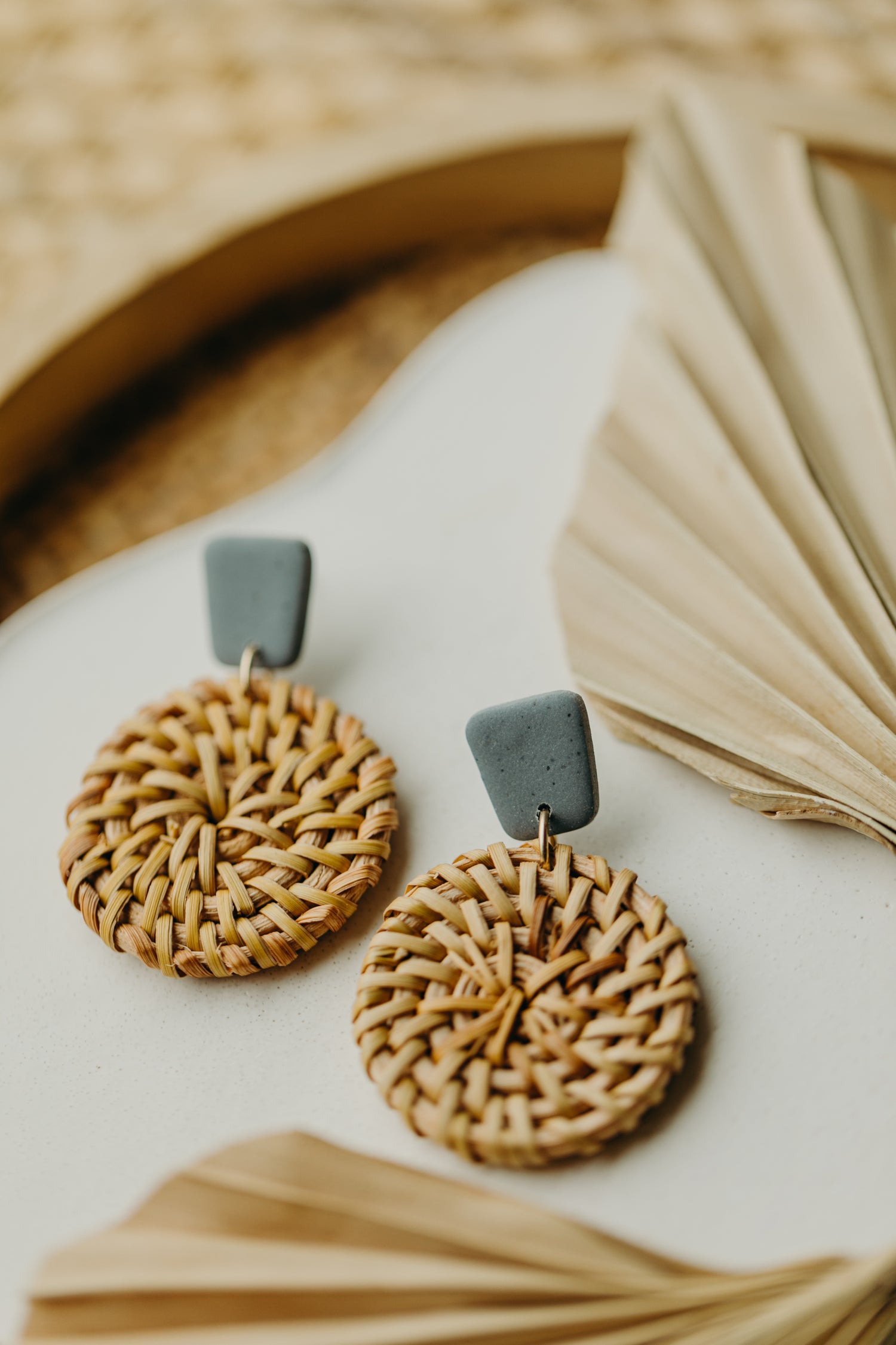 square polymer clay earrings in the color light denim blue with round rattan pendant